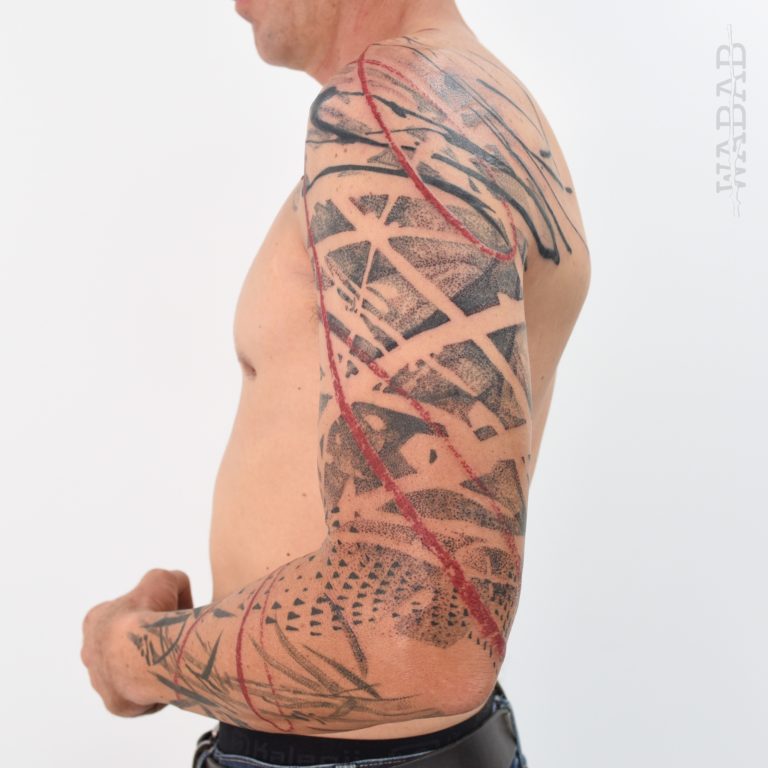 Tattouage abstrait de Wabab d’un bras en noir et rouge